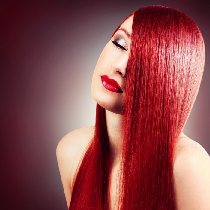 Woman with long red straight hair and red lipstick
