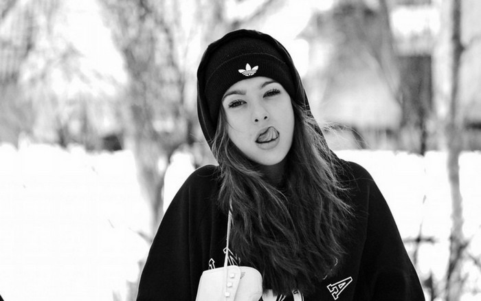Woman in beanie and hoodie sticking tongue out