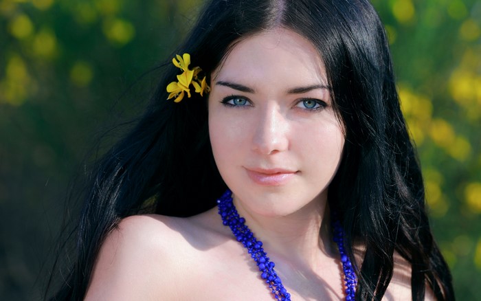 Woman with black hair and blue eyes outdoors
