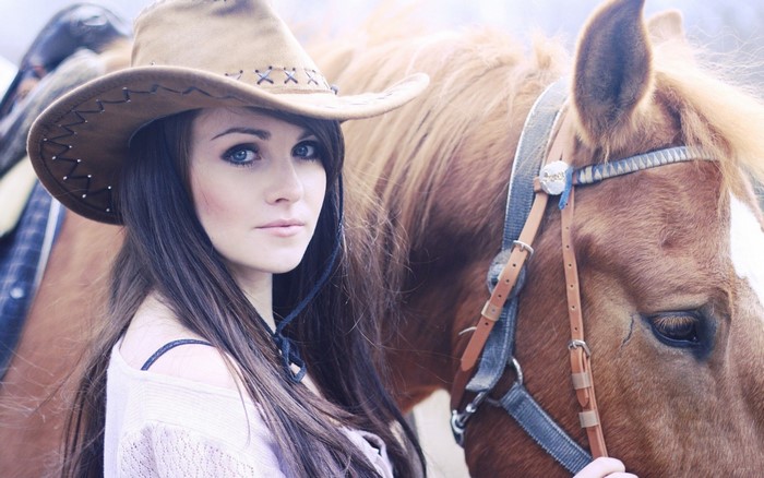 Woman in cowboy hat with horse