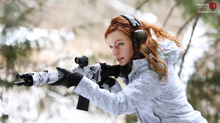 Woman with rifle in winter forest