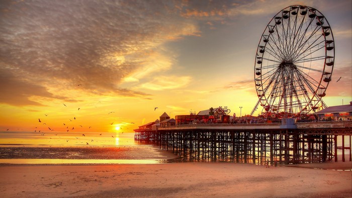 Sunset over Blackpool Pier with Ferris Wheel and Birds