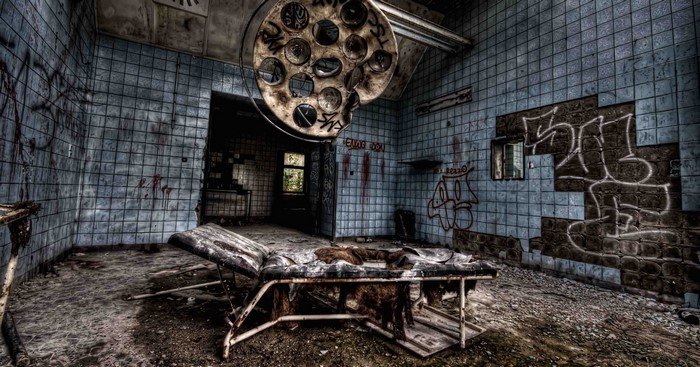 Abandoned operating room with graffiti and medical equipment