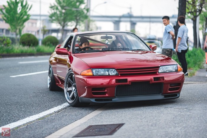 Red Nissan Skyline R32 with Volk Racing wheels on road