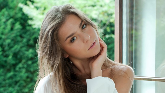 Woman with long hair by the window