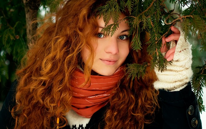 Redhead woman with blue eyes in winter forest
