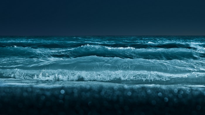 Waves crashing on the shore at night