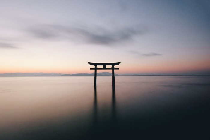 Torii gate in the sea at sunset
