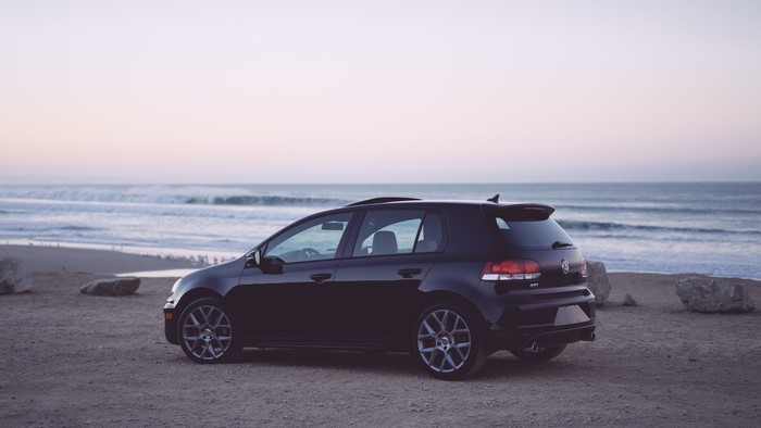 Black Volkswagen Golf GTI parked on a beach