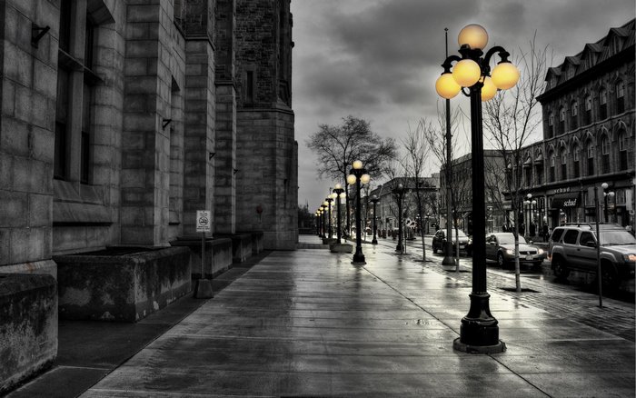Street lights and buildings on a wet sidewalk