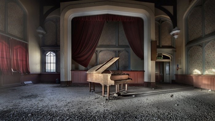 Abandoned room with grand piano and stage