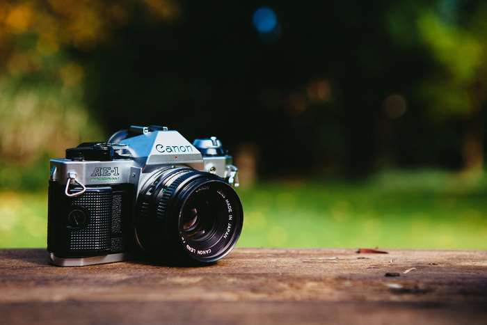 Canon AE-1 analog camera on wooden table