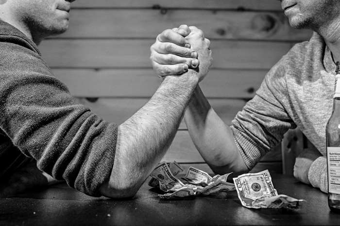 Men arm wrestling over money