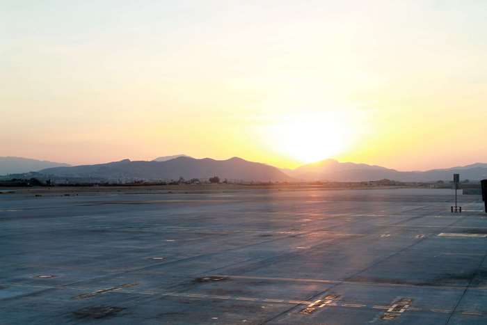 Airport runway at sunrise with mountains