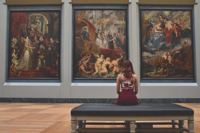 Woman looking at paintings in a museum