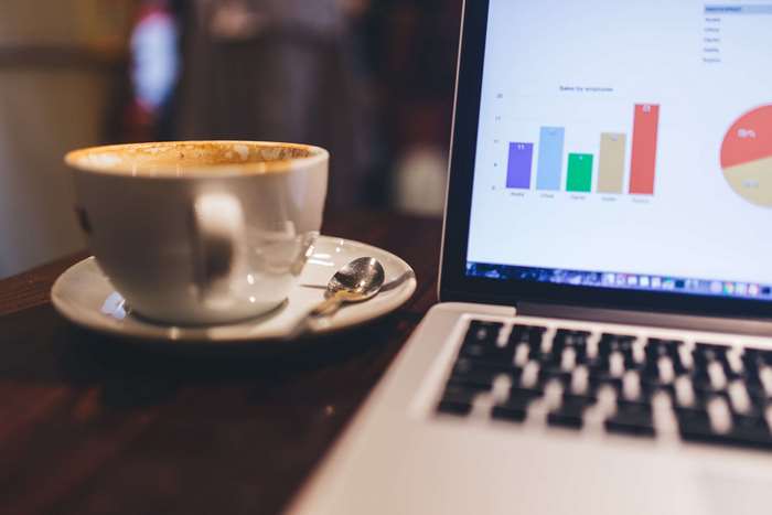 Coffee cup and laptop with charts 4K