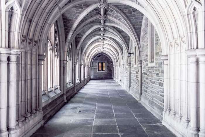 Gothic arched hallway with stone walls and floor