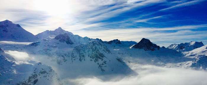 Snow-covered mountains under a bright sky