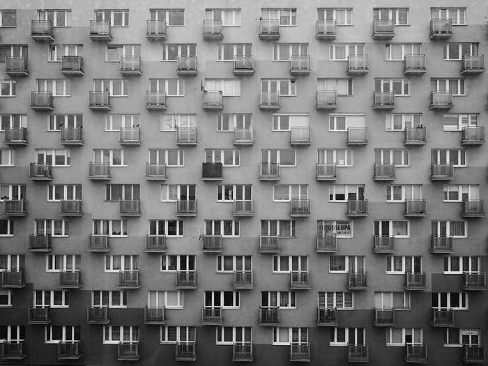 Black and white image of a block of flats with balconies and windows