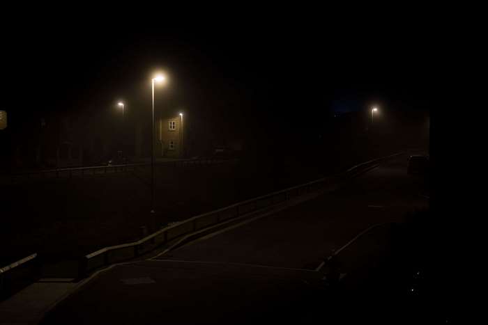 Streetlights at night on a foggy road