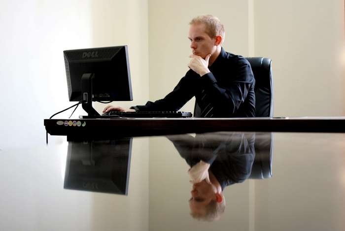 Man in black shirt working on Dell computer at desk