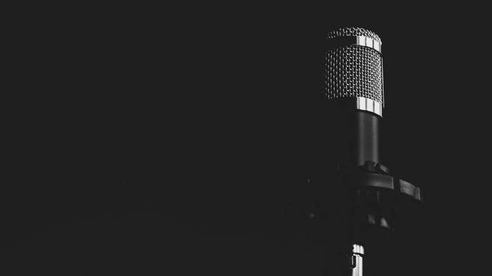 Close up of a silver microphone on a black background
