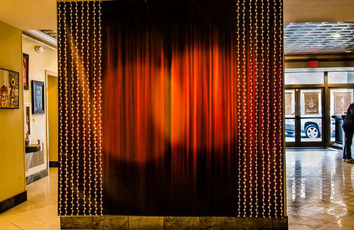 Stage backdrop with orange curtains and string lights
