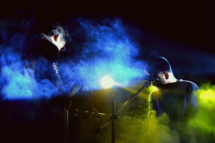 Band performing on stage with smoke and lights