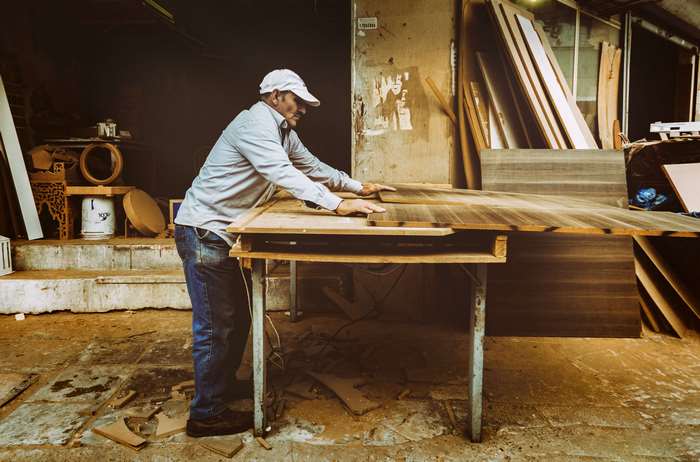 Carpenter working on a wooden table in a workshop 4K