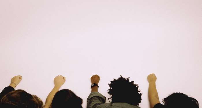 Diverse group of people raising fists