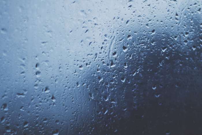 Close up of raindrops on a blue glass window