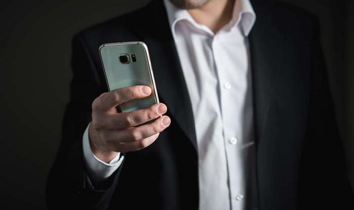 Man in Suit Holding Smartphone