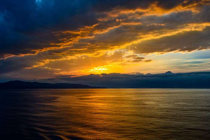 Sunset over the Mediterranean Sea with Island and Stormy Clouds