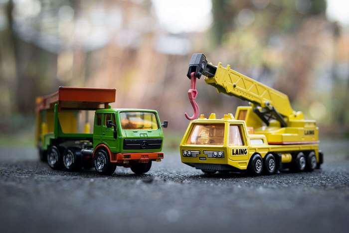 Toy dump truck and crane truck on asphalt