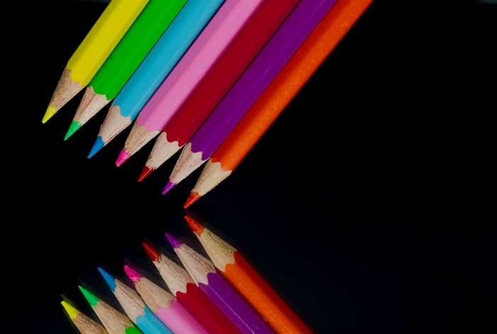 Colored pencils arranged in a pattern with reflection