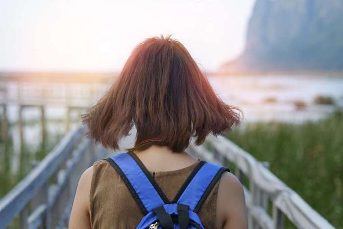 Woman with backpack on wooden walkway