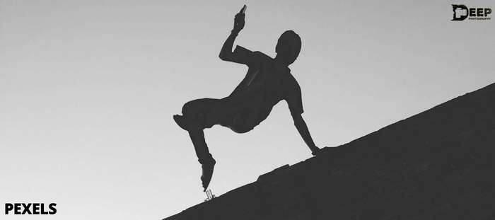 Silhouette of a person performing parkour on a rooftop