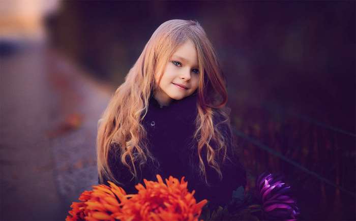 A young girl with long blonde hair and flowers