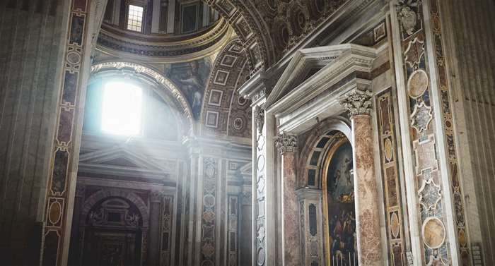 Interior of a grand church with sunlight streaming through a window