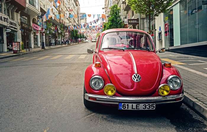 Red Volkswagen Beetle parked on a city street