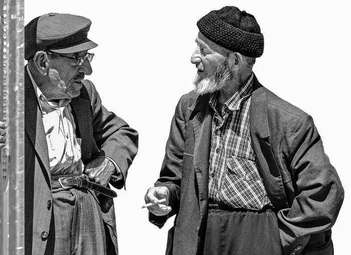 Two elderly men talking and smoking