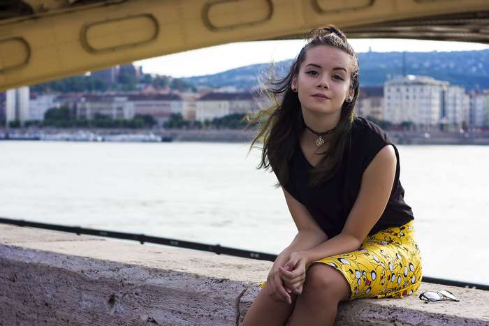 Young woman sitting by a river in Budapest
