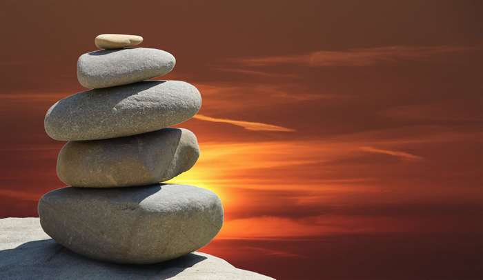 Stacked stones against a sunset sky