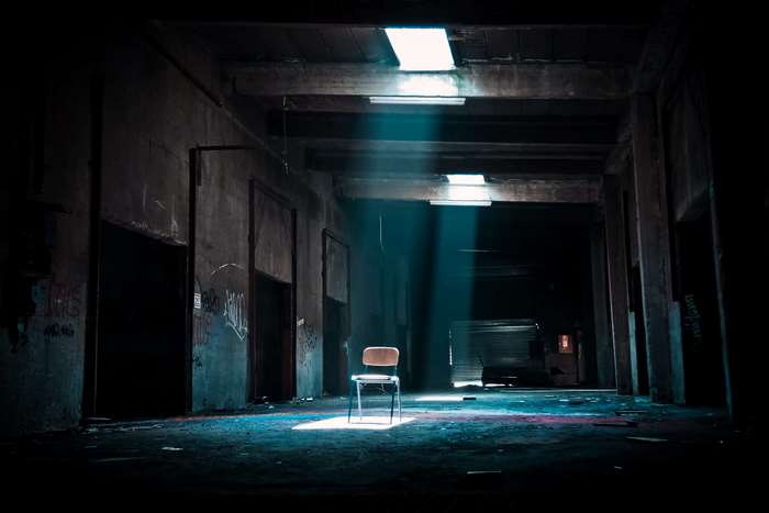 Abandoned building with chair in sunlight