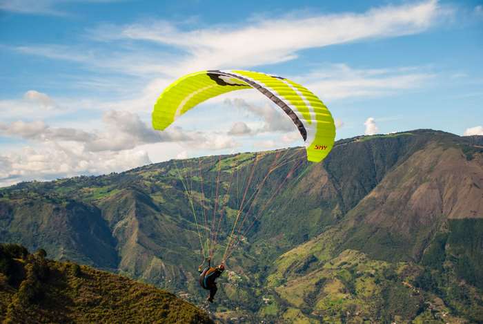 Paragliding over green mountains in 4K