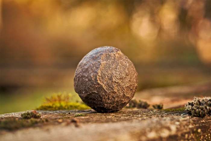 Close up of a rough stone on a mossy surface
