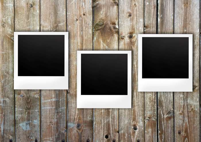 Three blank polaroid photos on a wooden background