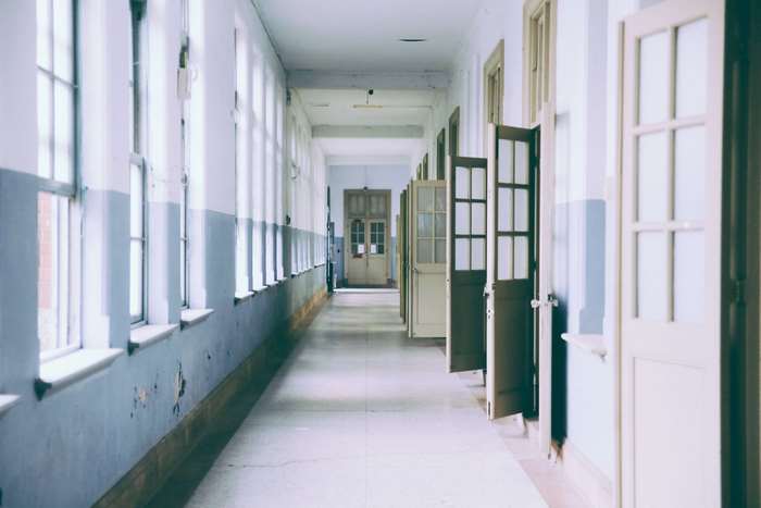 Empty school hallway with windows and doors