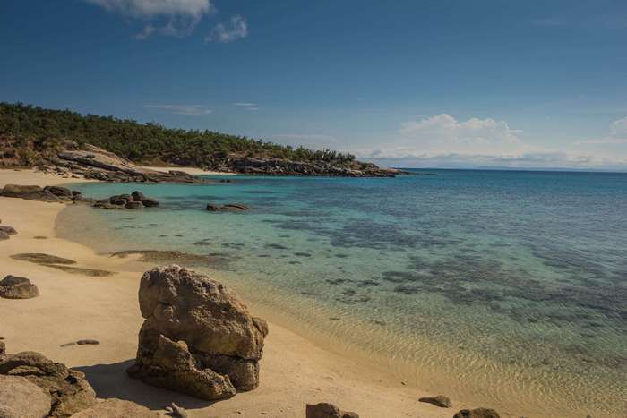 Beach with clear turquoise water and rocky coastline