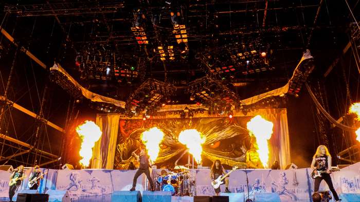 Iron Maiden performing live with fire effects on stage